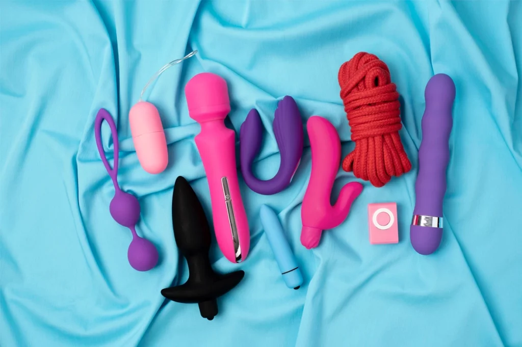 ensemble de gode, vibromasseurs et sextoys sur un drap bleu