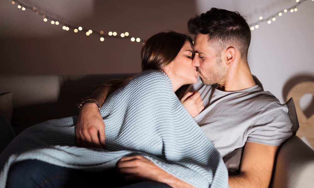 Couple qui s'embrasse dans un lit avant de parler cochon