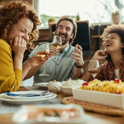 personnes qui rient à table en parlant de sexe