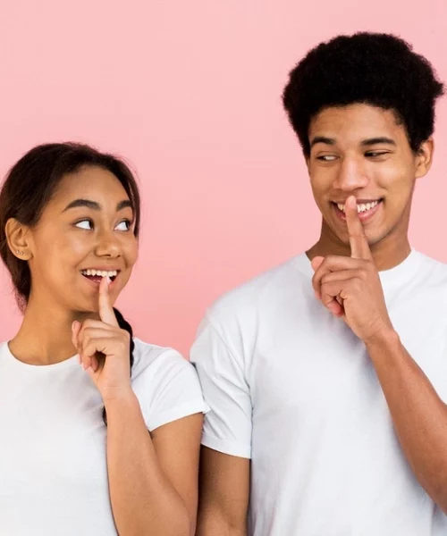 Couple de jeunes avec leur doigt devant la bouche, article "ken chez ses parents"