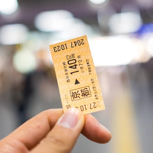 Un ticket de métro tenu dans une main avant de le couper